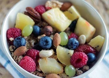 un bol de fruits, d'amandes et de céréales pour un petit déjeuner spécial ventre plat
